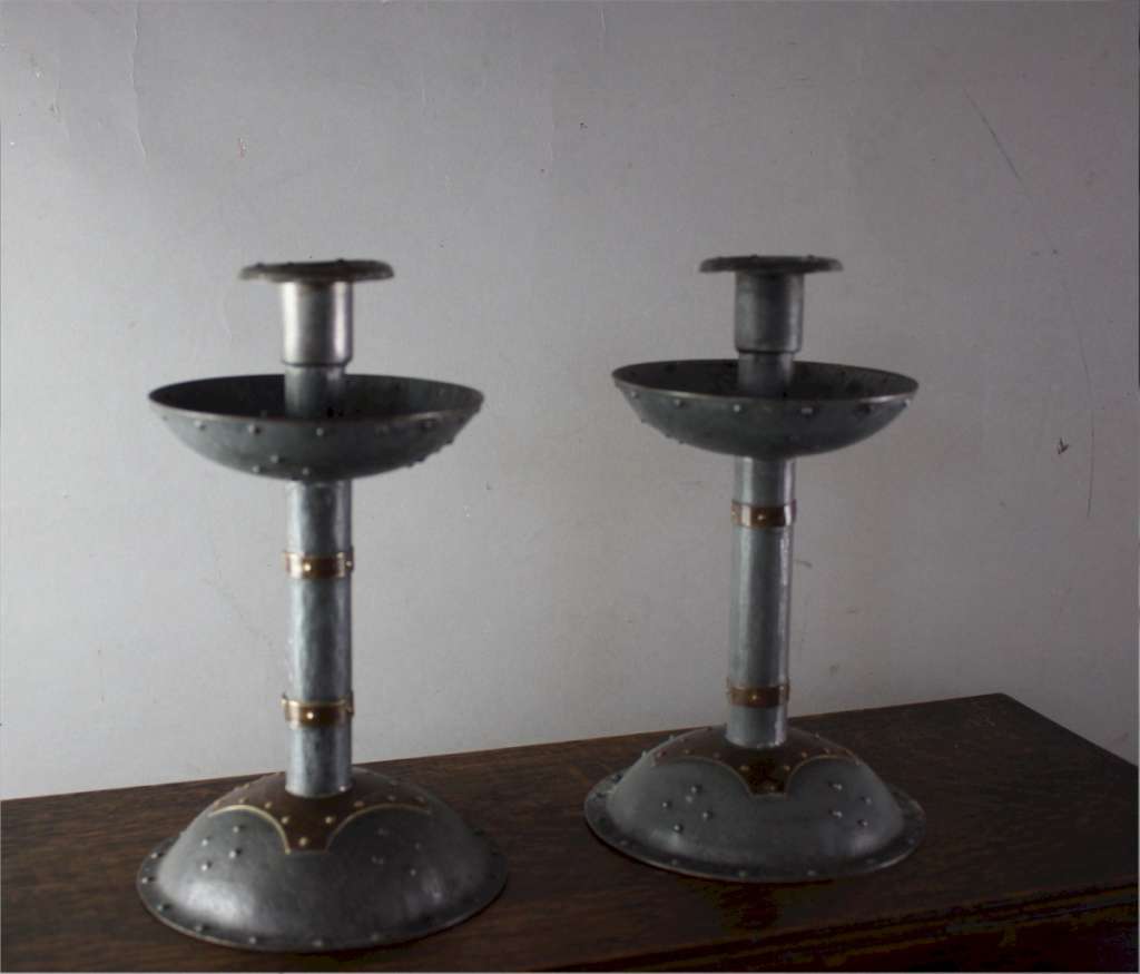 Pair of arts and crafts steel and brass candlesticks