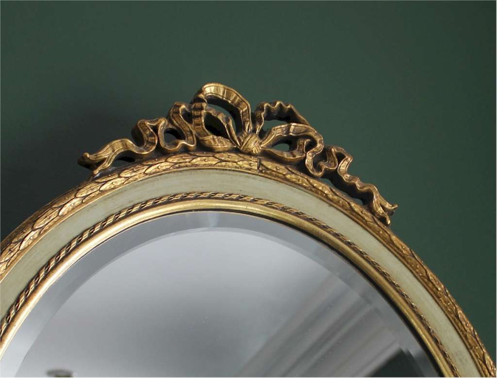 Pair of French gilt and painted wood oval mirrors