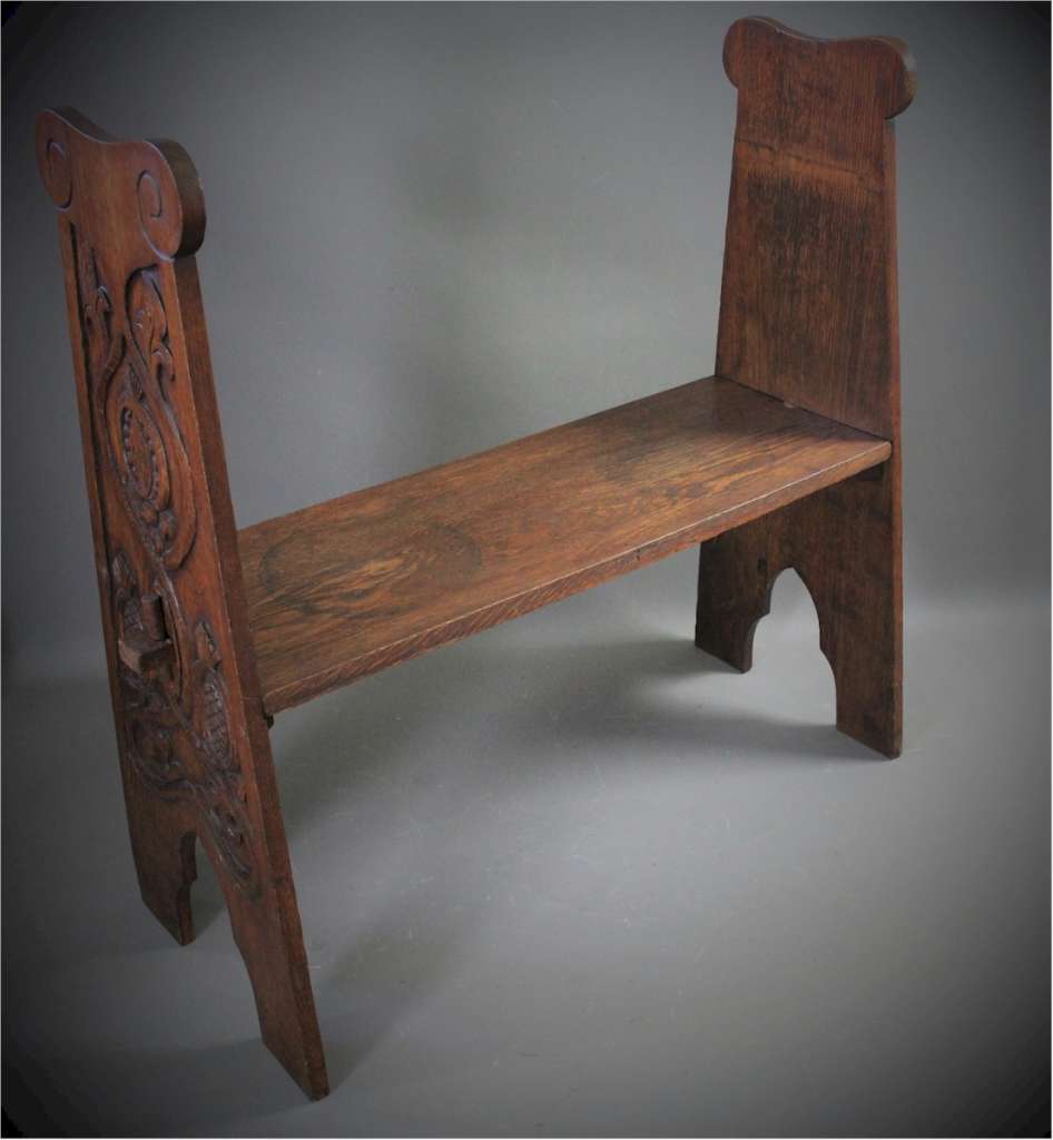 Arts and Crafts oak bench with carved pomegranates