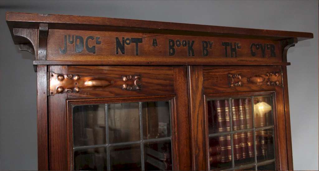 Arts and Crafts bookcase with Motto, Judge not a book by the cover.