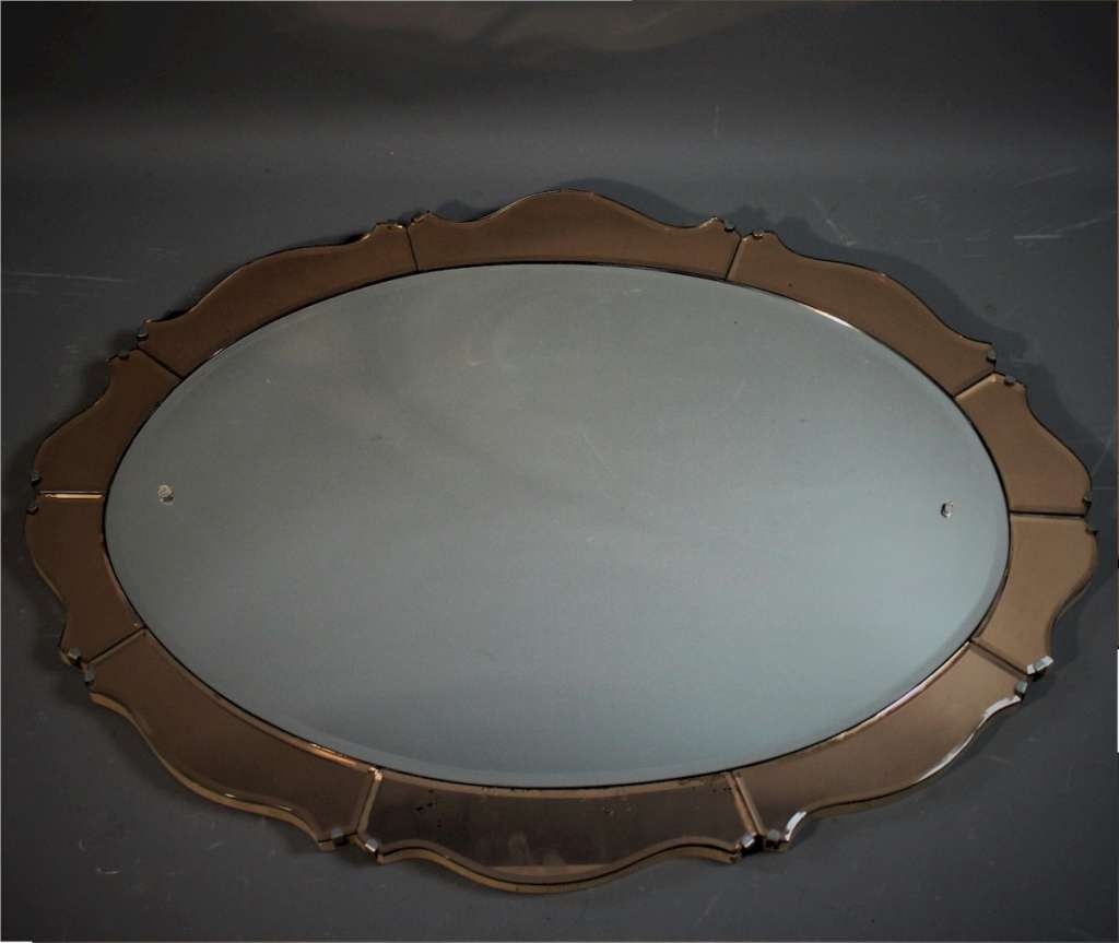 Art Deco oval mirror with peach scalloped border.