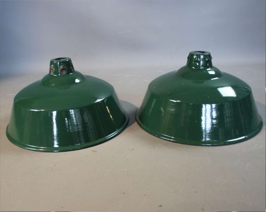 Two green enamelled industrial shades.